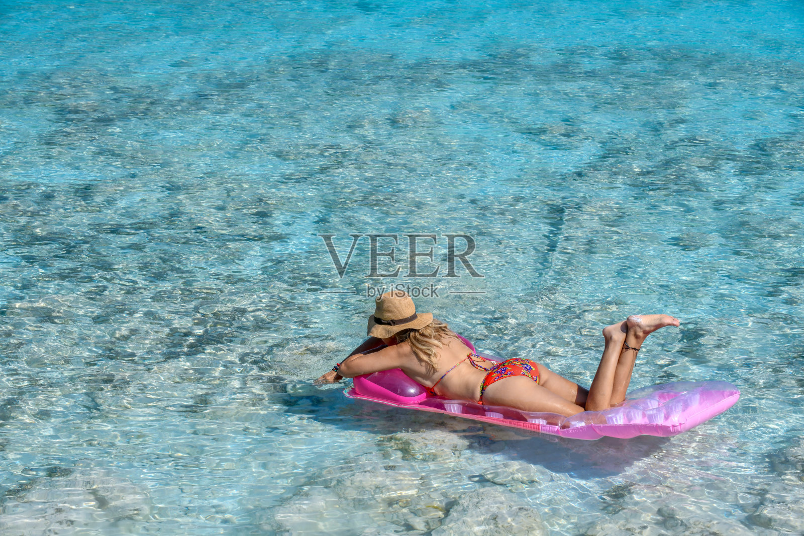 一个穿着红色泳衣的女人躺在湖底。照片摄影图片