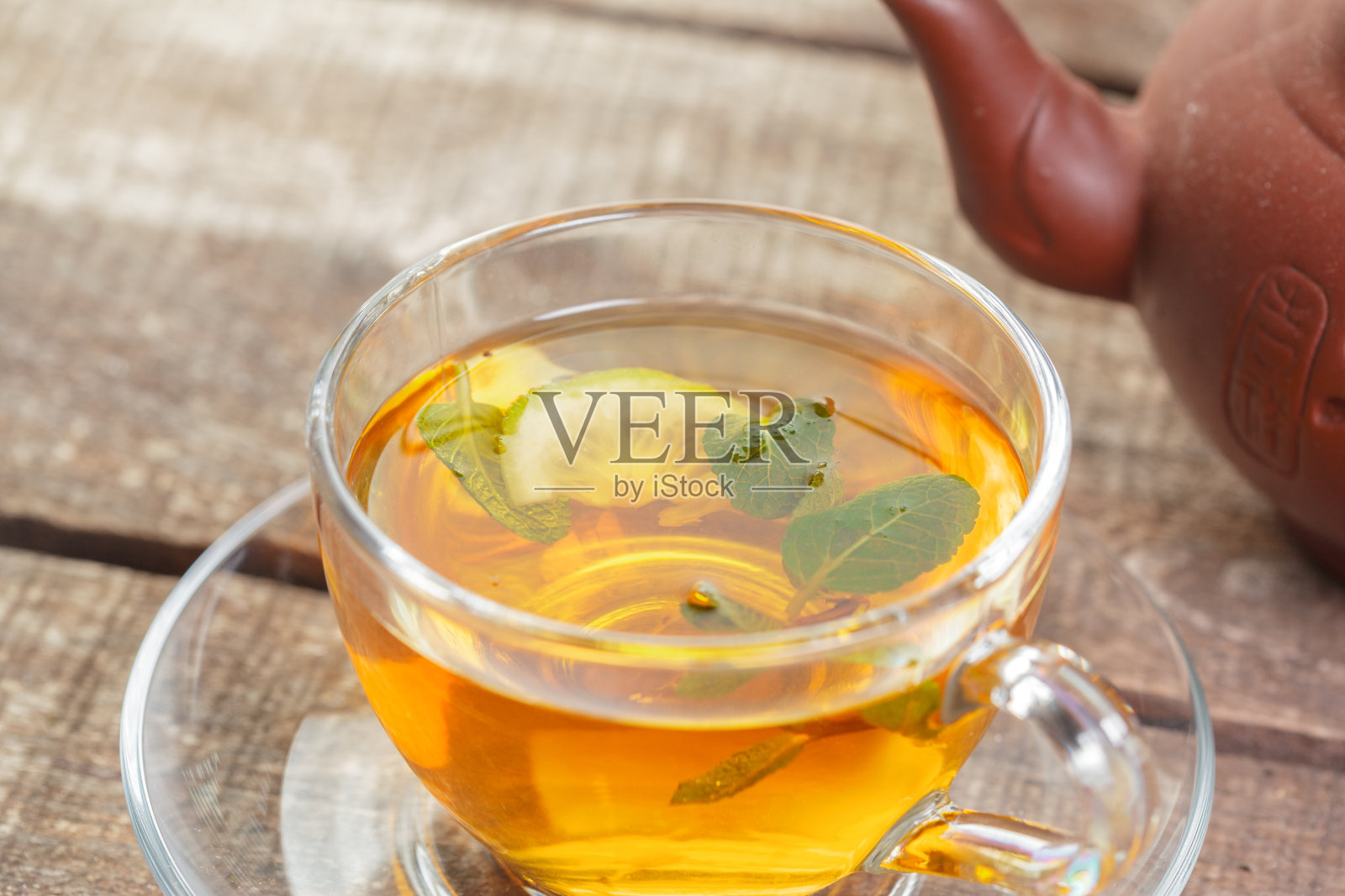 木桌上放着一杯薄荷叶红茶照片摄影图片