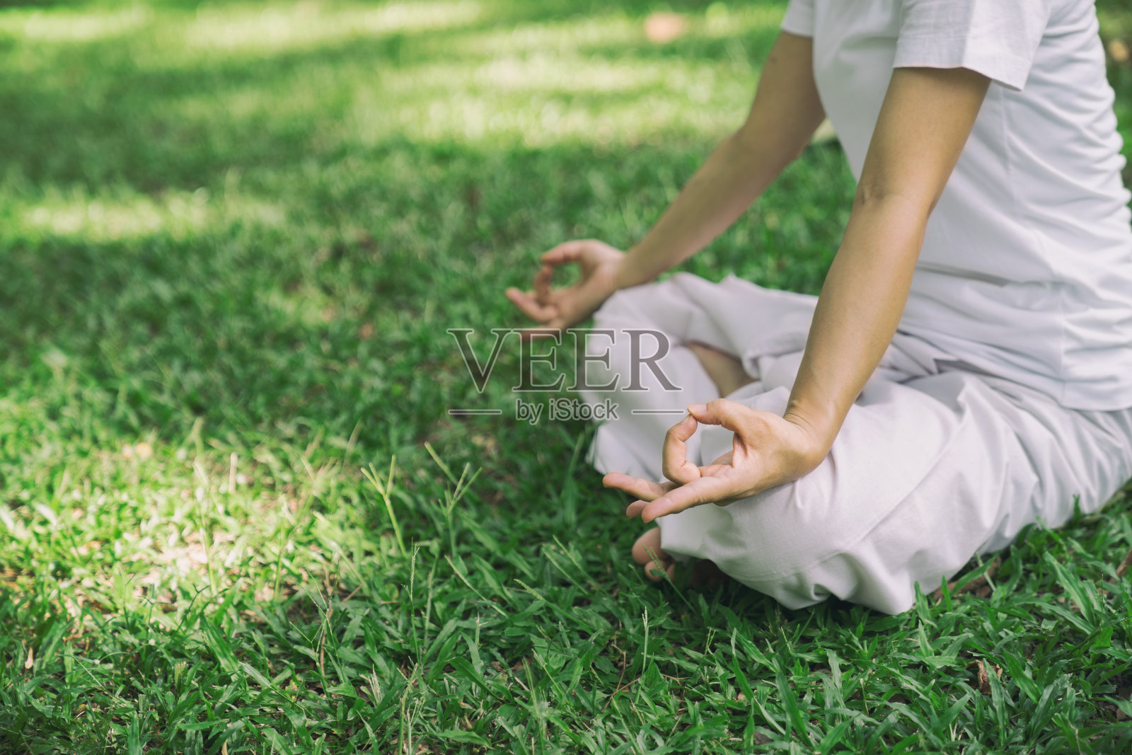 在公园里练瑜伽和打坐的女人感到轻松、平静、快乐。照片摄影图片