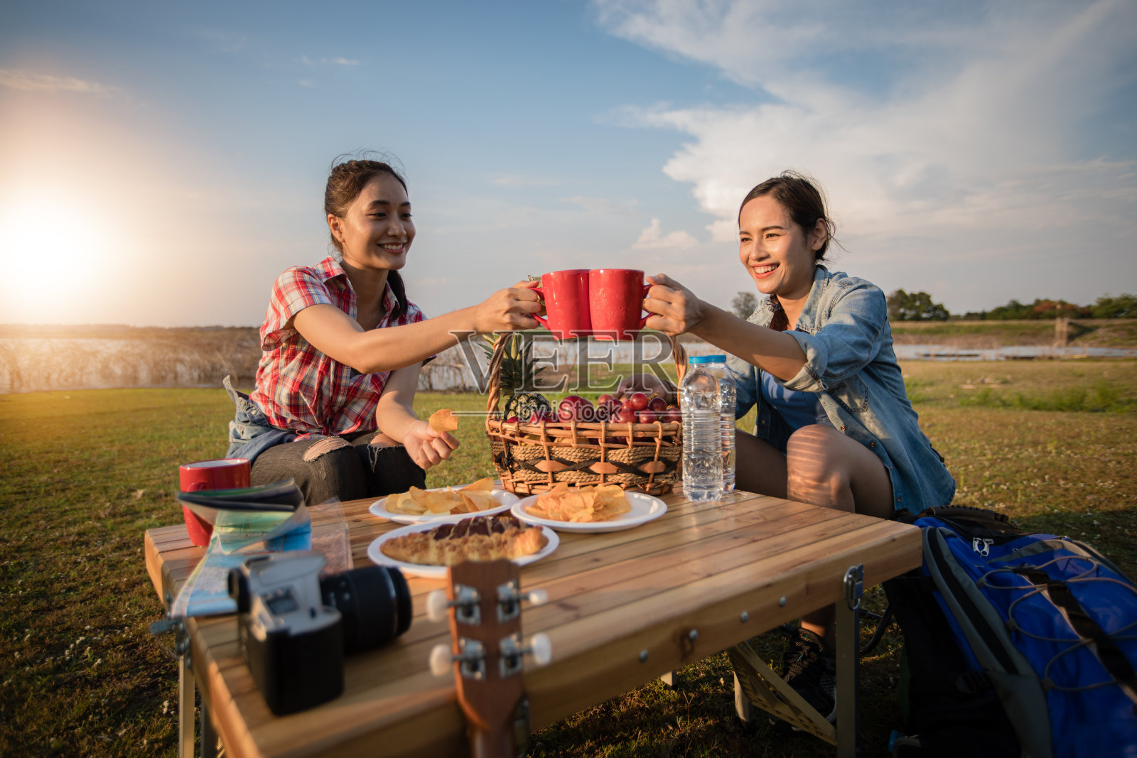 一群亚洲朋友在暑假喝咖啡和花时间野餐。他们在假期很快乐，玩得很开心。照片摄影图片