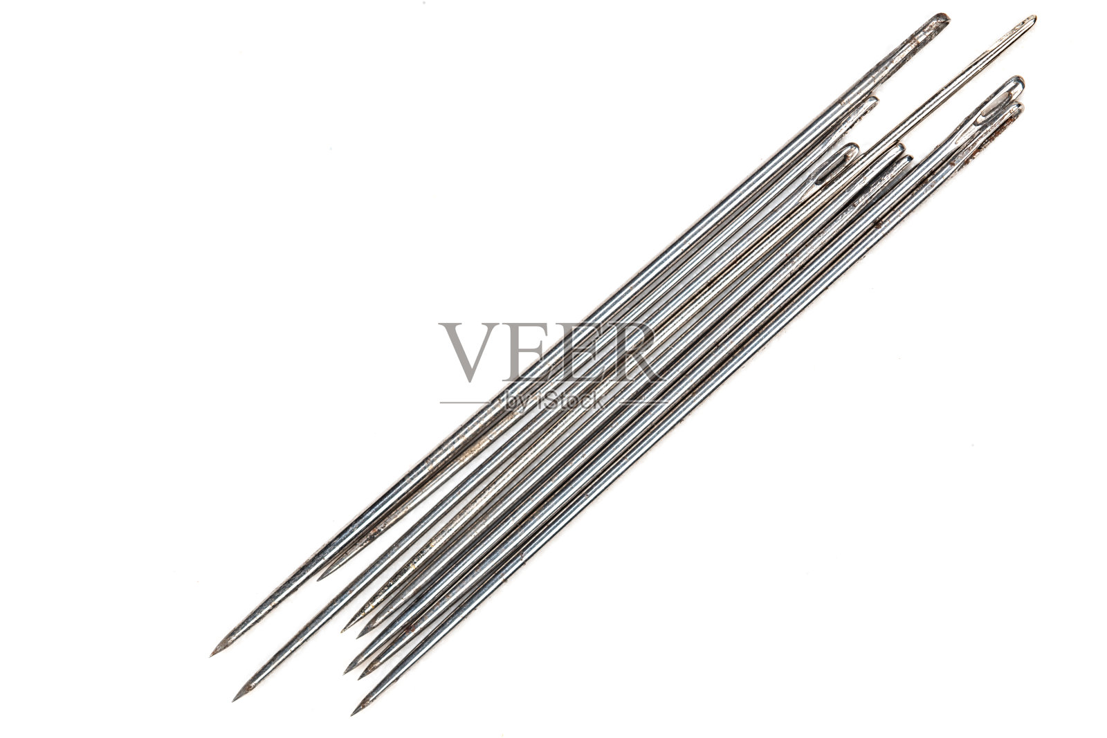 生锈的手缝针特写在白色的背景。照片摄影图片