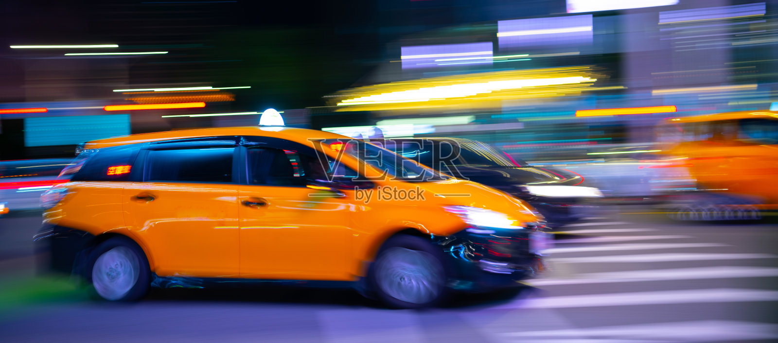 黄色出租车在台北的车流中，夕阳刚过，模糊的运动照片摄影图片