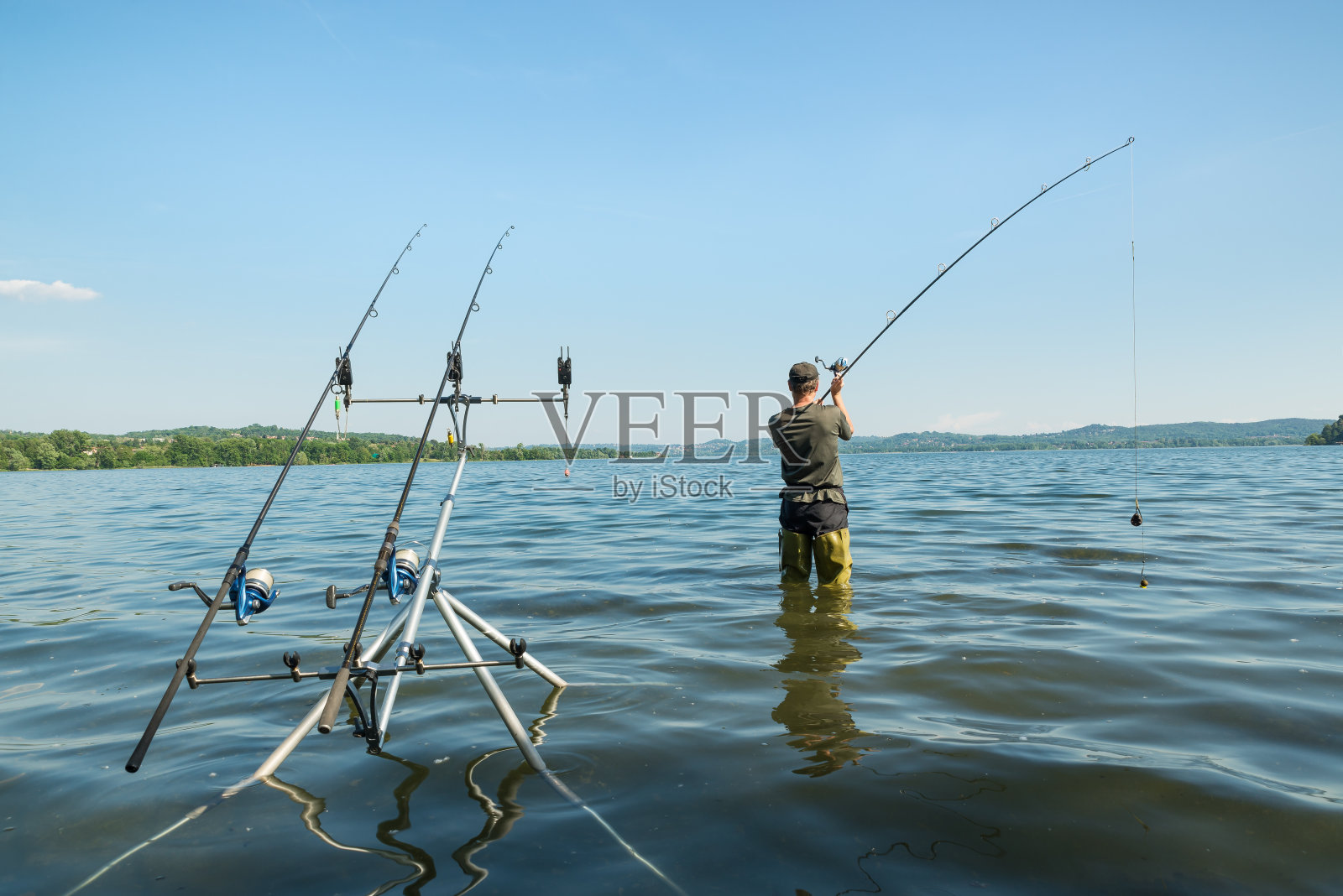 钓鱼历险，钓鲤鱼。渔夫在抛鱼饵照片摄影图片