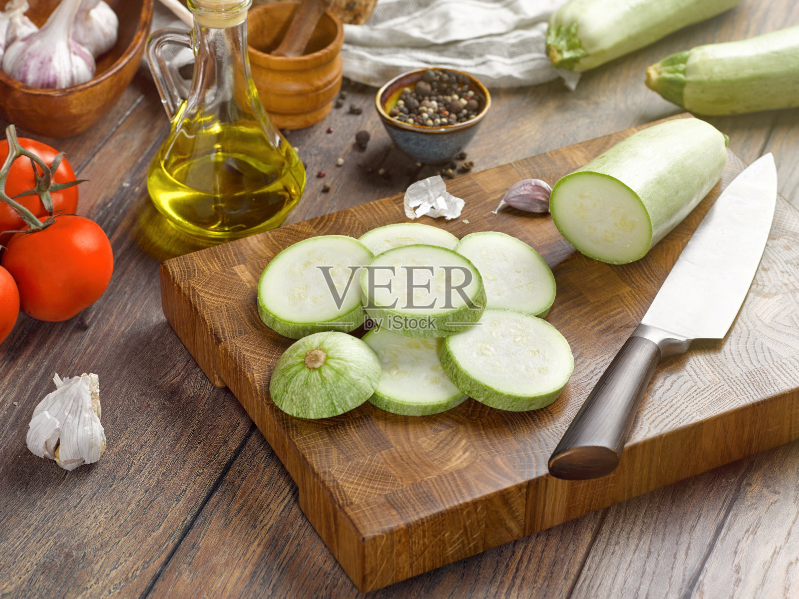 一个漂亮的木质切菜板，上面有西葫芦片。照片摄影图片