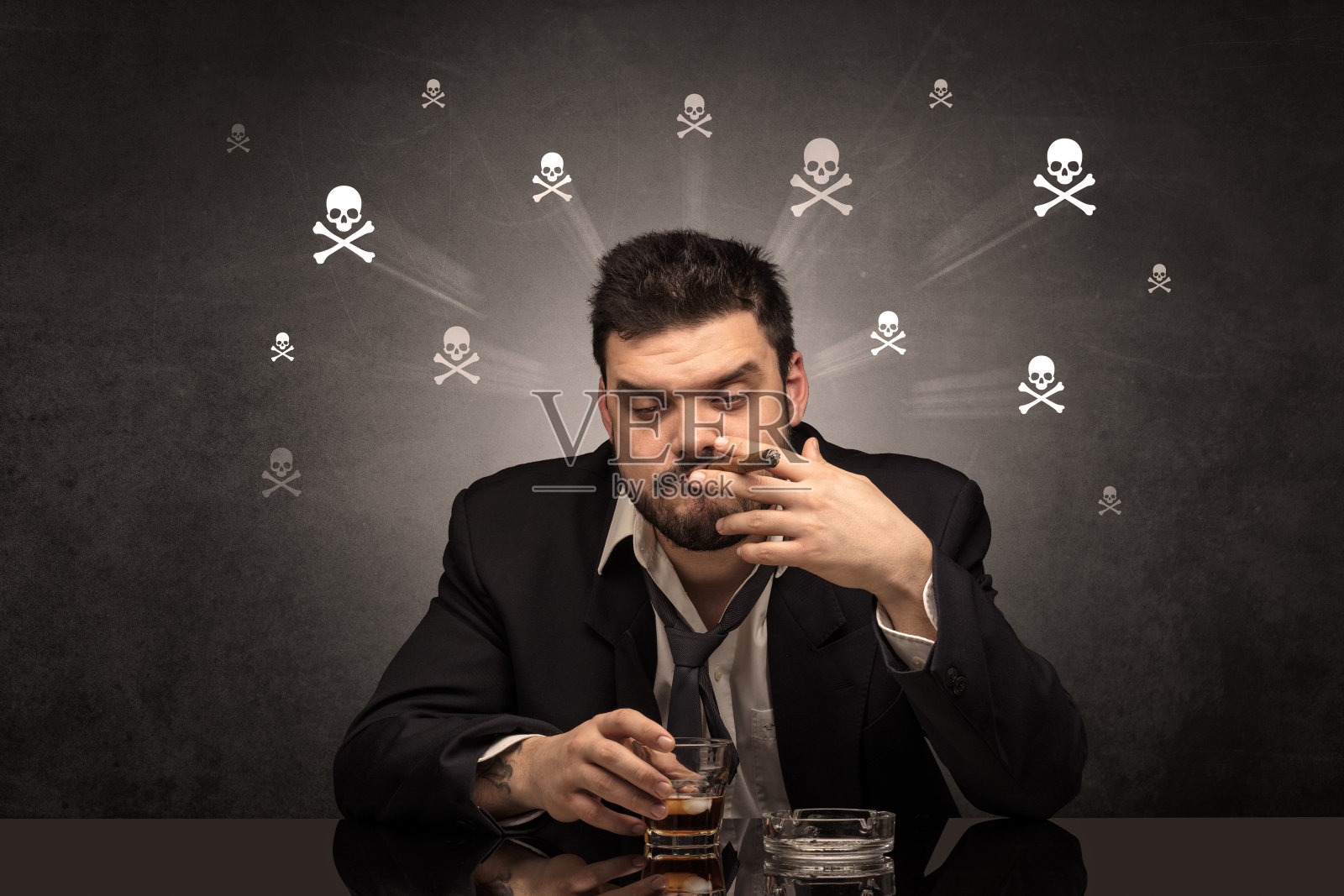 醉鬼坐在桌子前，脑子里装着骷髅照片摄影图片