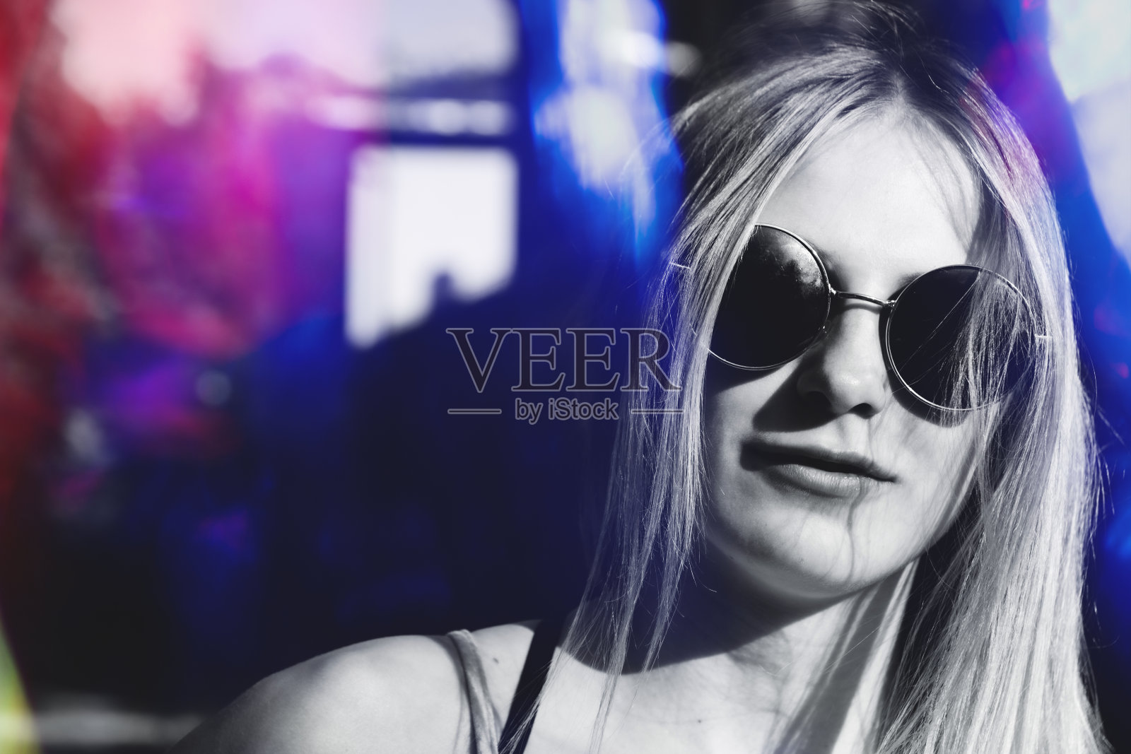 一个戴着眼镜，带着城市灯光的女人的肖像照片摄影图片