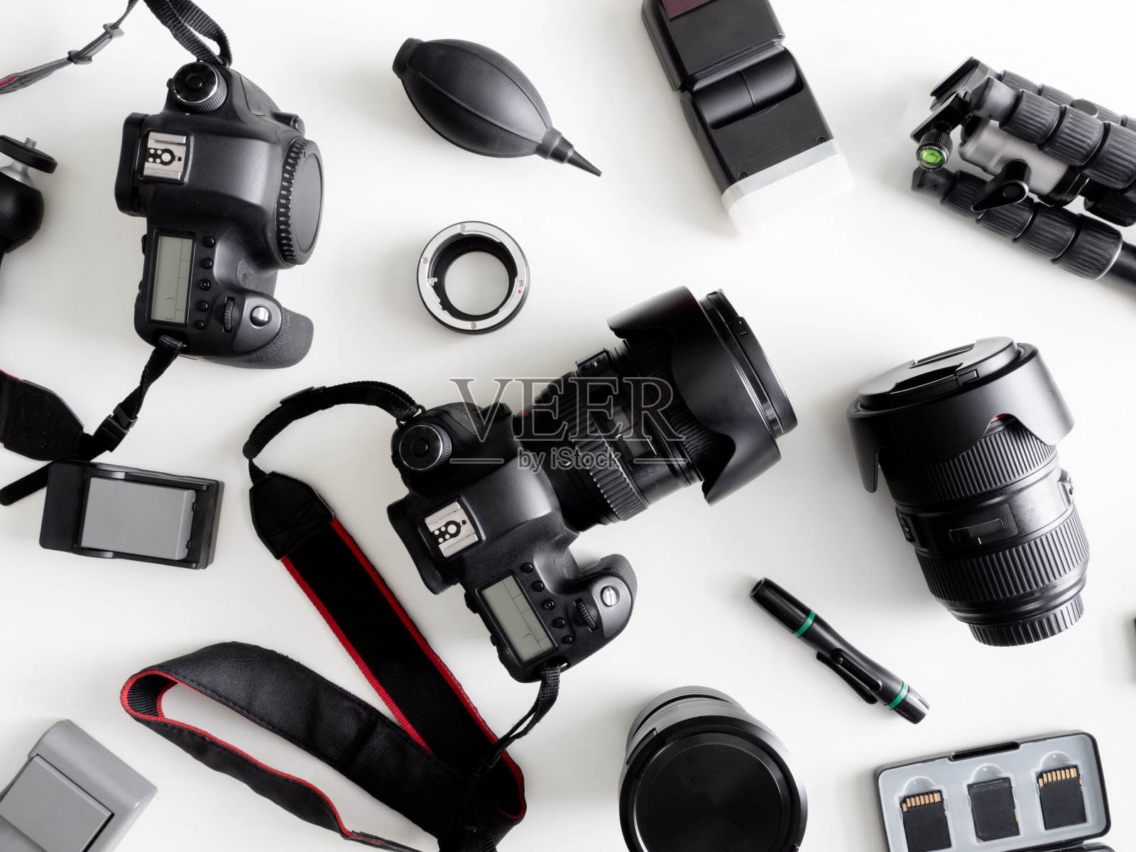 工作空间摄影师的俯视图与数码相机，闪光灯，清洁工具包，记忆卡，三脚架和相机配件在白色的桌子背景照片摄影图片