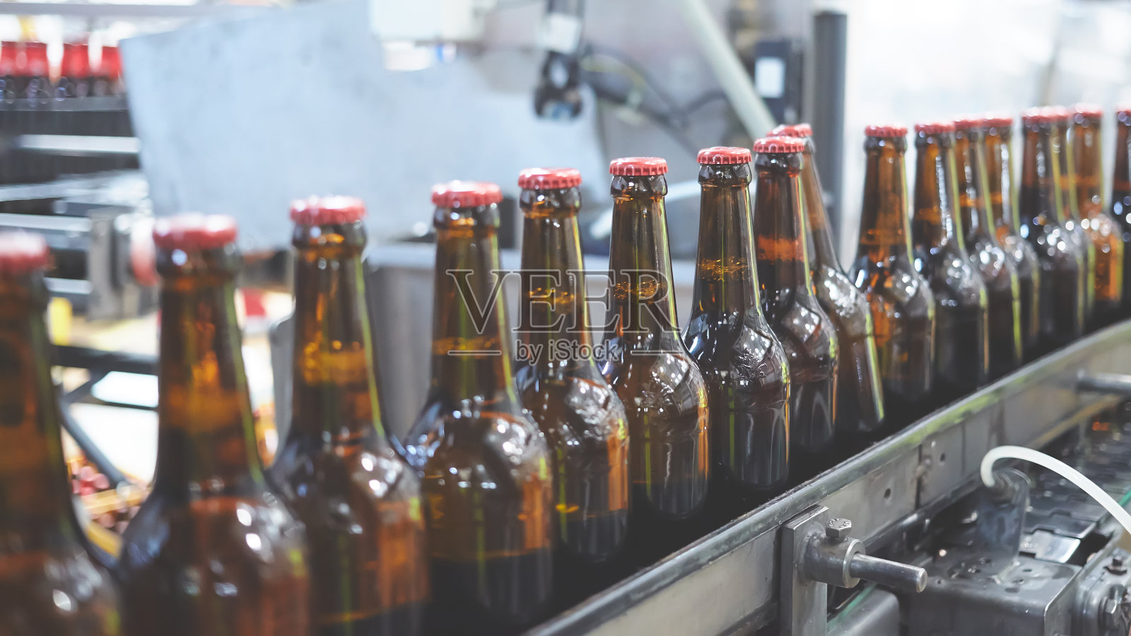传送带上的啤酒瓶。浅景深。有选择性的重点。照片摄影图片