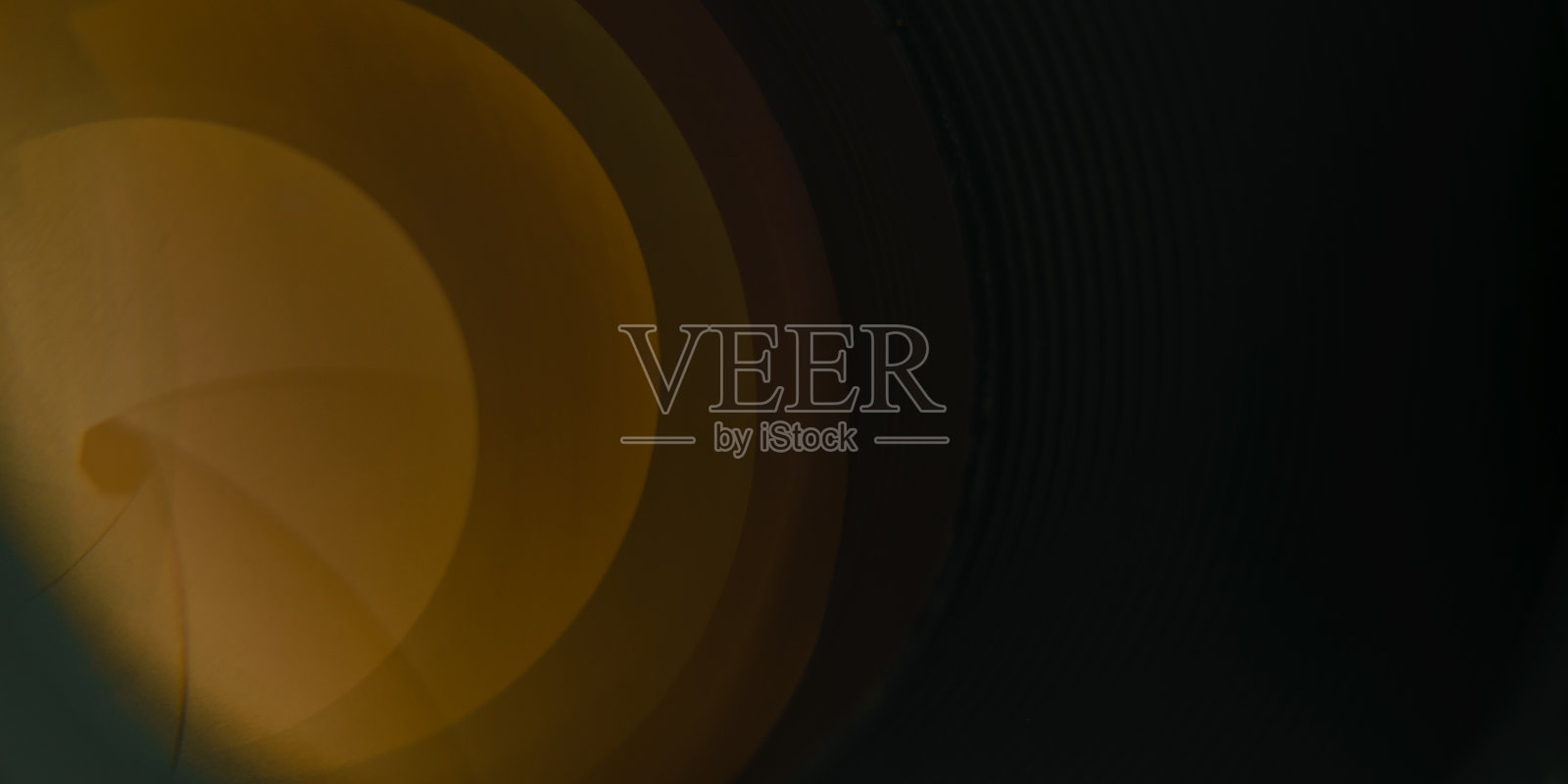 美丽的相机镜头与黄色的玻璃反射在黑色的背景。照片摄影图片