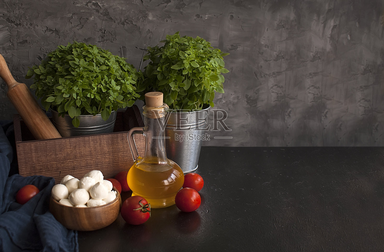 披萨的配料:马苏里拉奶酪、西红柿、罗勒、橄榄油、奶酪和香料放在一张质朴的木桌上。意大利比萨玛格丽塔。本空间照片摄影图片