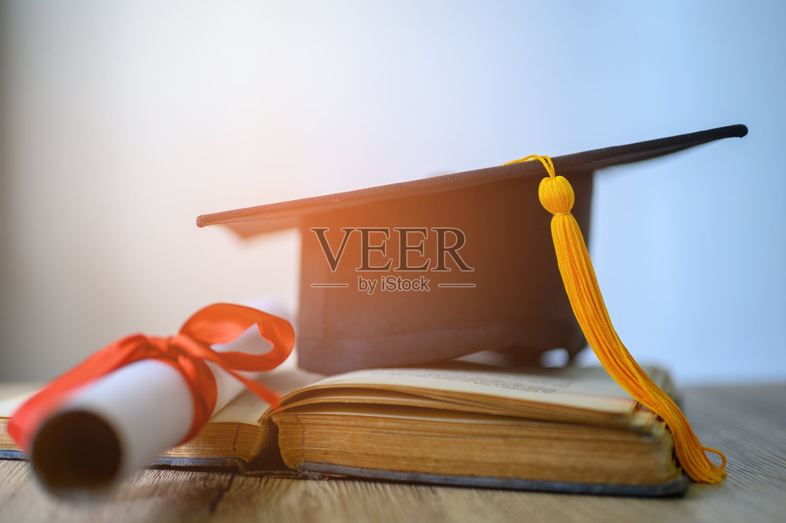 黑色毕业生的帽子和桌子上的书照片摄影图片