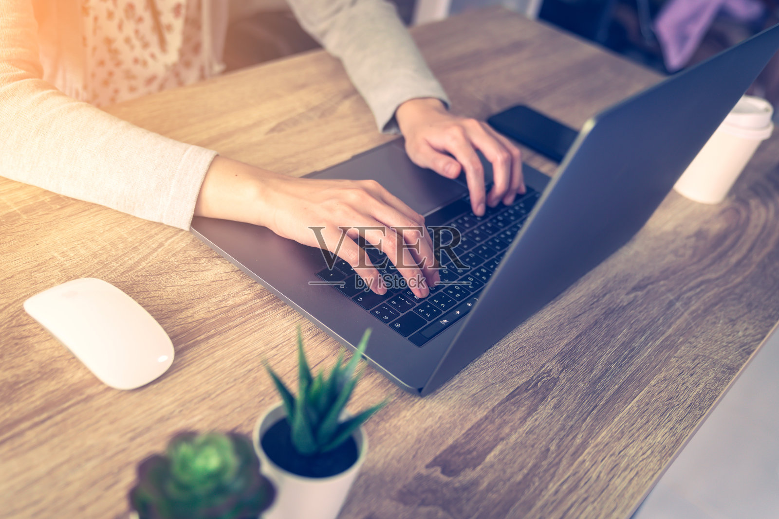 亚洲妇女使用笔记本电脑做在线活动在家庭办公室的木桌上。照片摄影图片