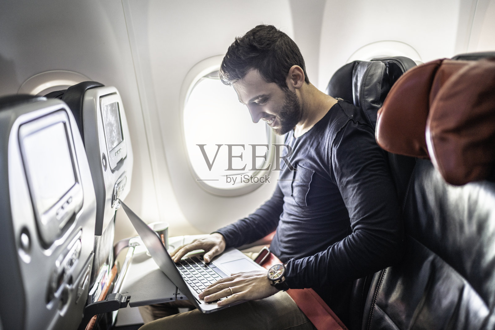 在飞机上使用笔记本电脑的男人照片摄影图片