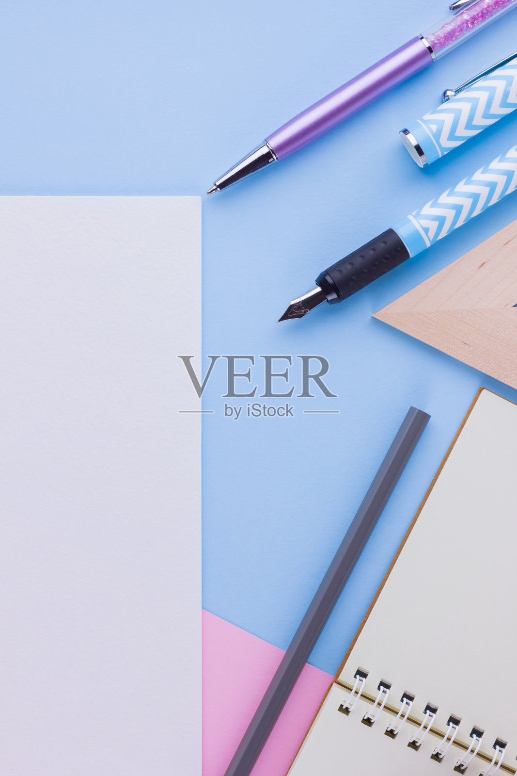 回到学校的概念。粉蓝色背景的学校文具和贝壳。钢笔，铅笔和gon在柔和的背景。前视图。本空间照片摄影图片