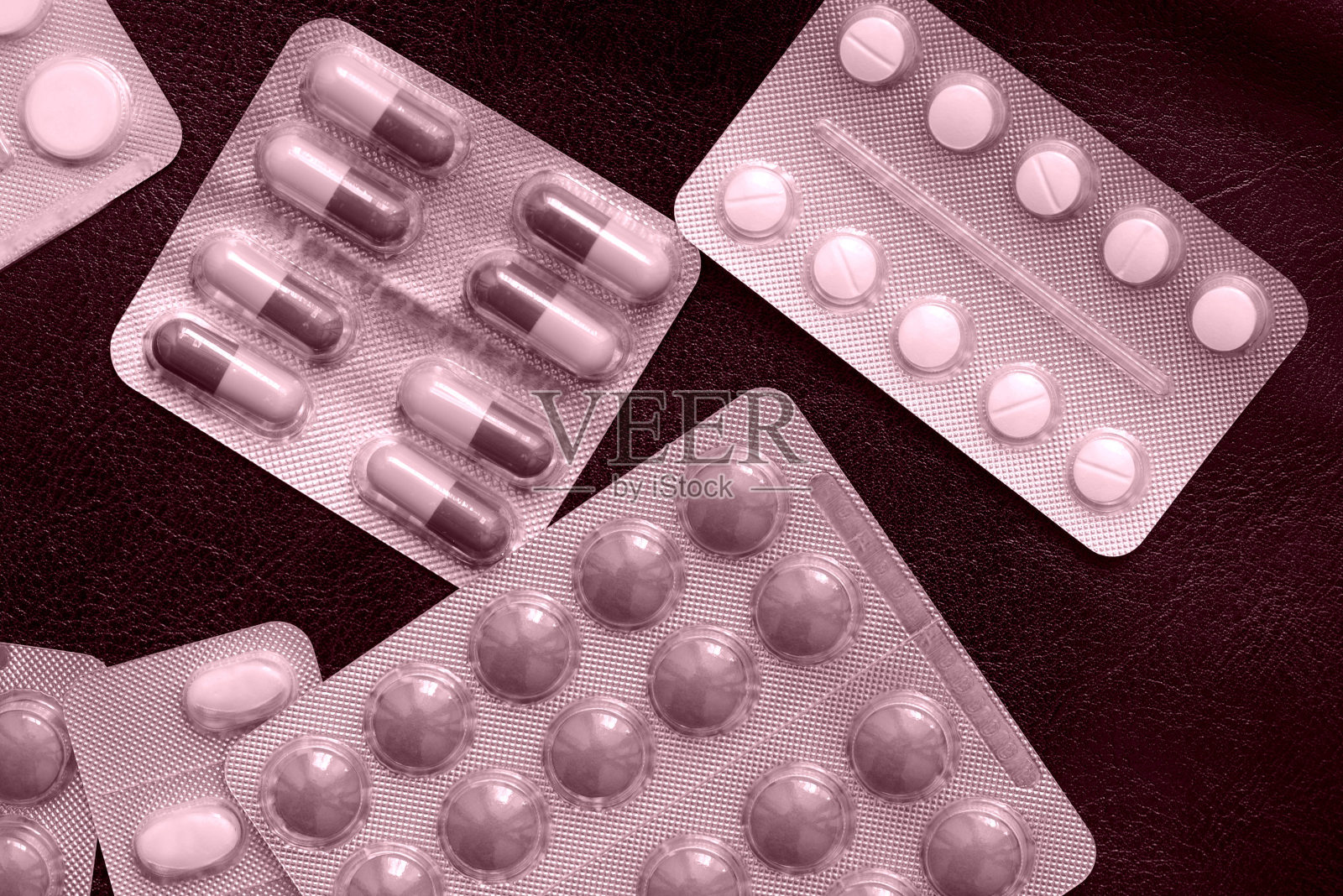 药片和水泡分散在一个黑暗的背景接近粉红色调照片摄影图片