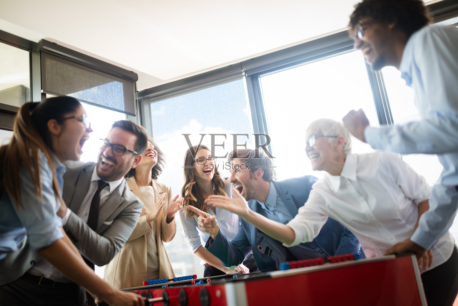 同事们在休息时间玩桌上足球照片摄影图片