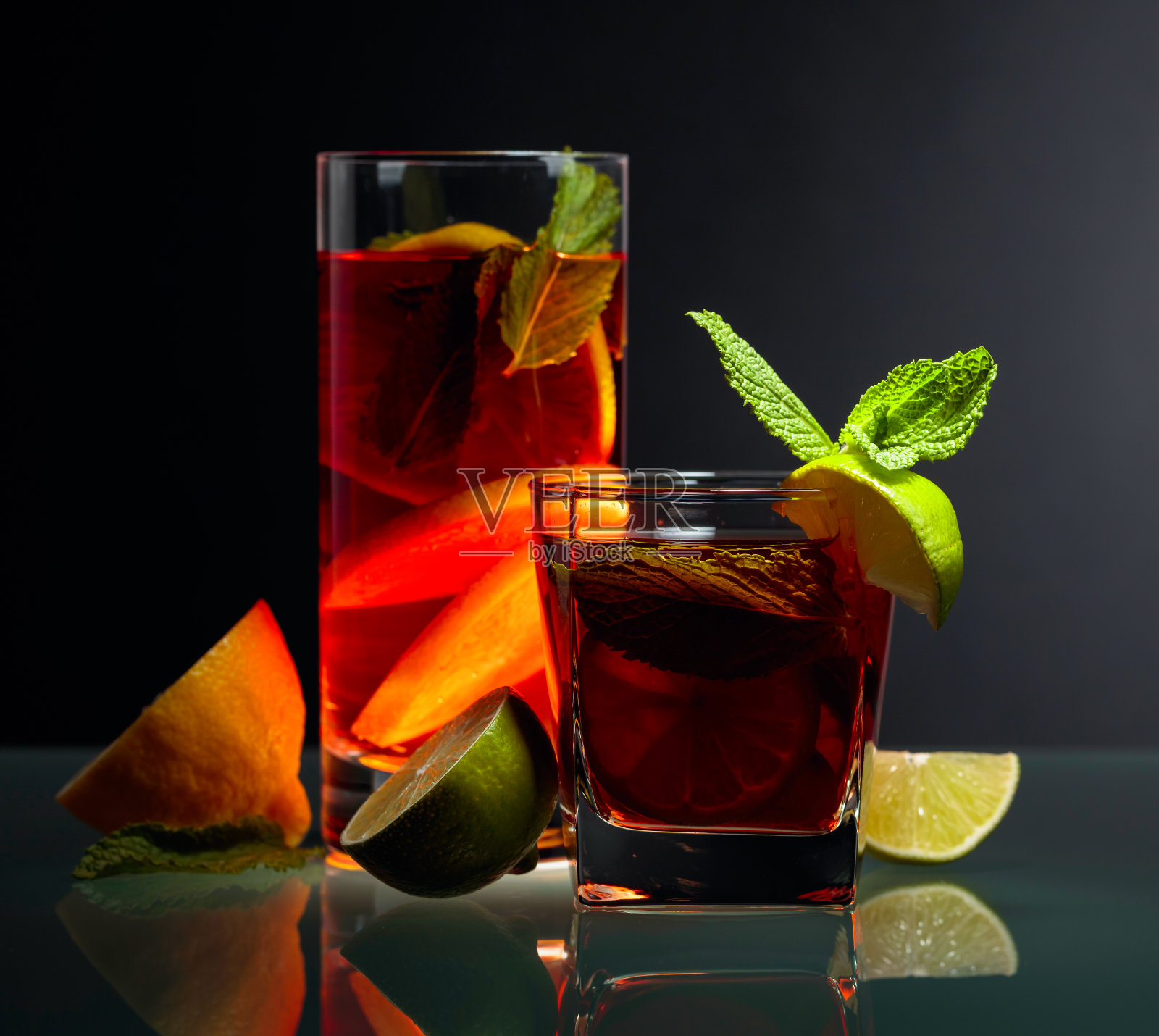 玻璃桌上放着柠檬、柠檬和薄荷凉茶。照片摄影图片