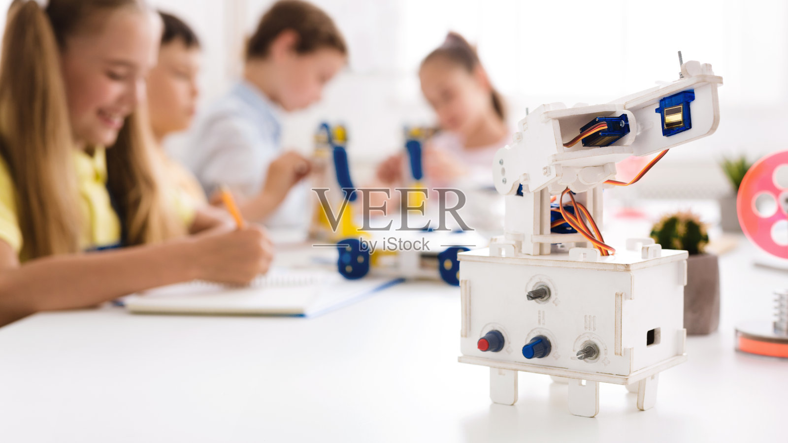 机器人在前面，孩子们在课堂上学习照片摄影图片