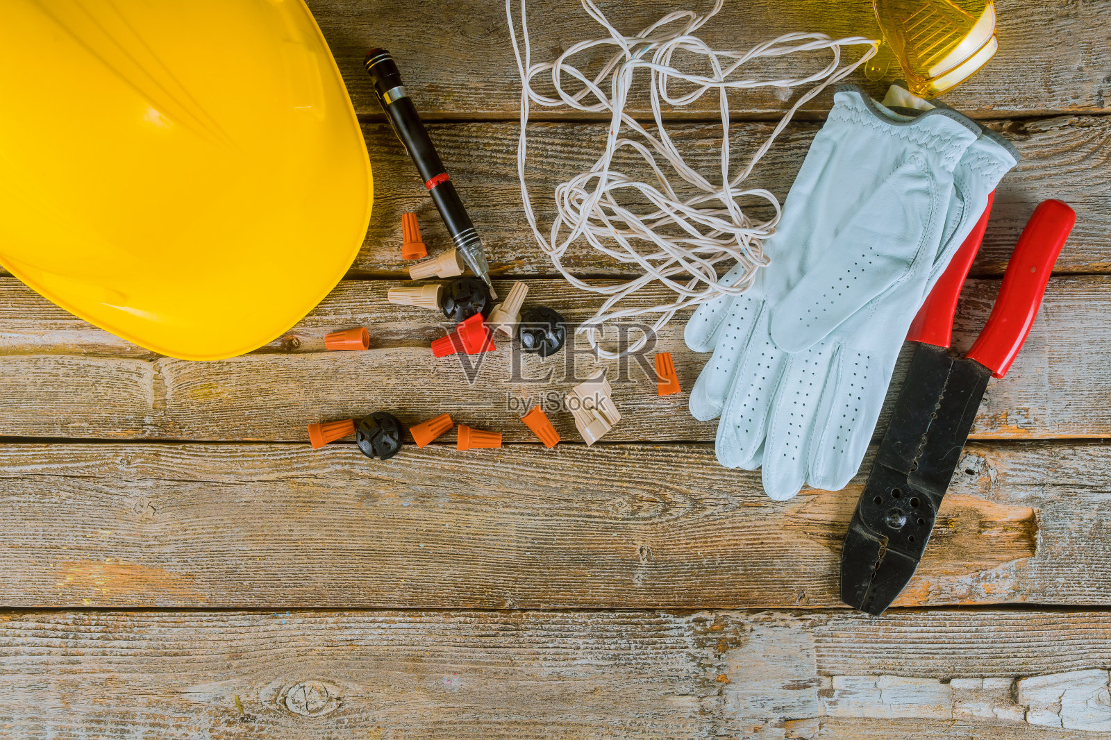 工作中的电工准备电气安装中使用的工具和电缆，并准备黄色头盔照片摄影图片