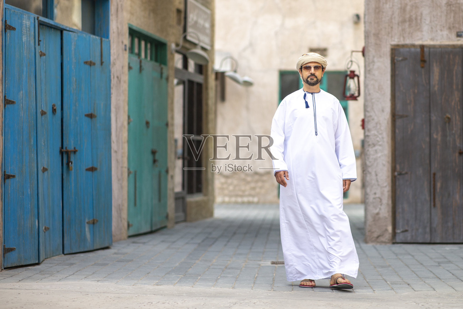 在迪拜老城区Al Seef行走的阿拉伯男子照片摄影图片