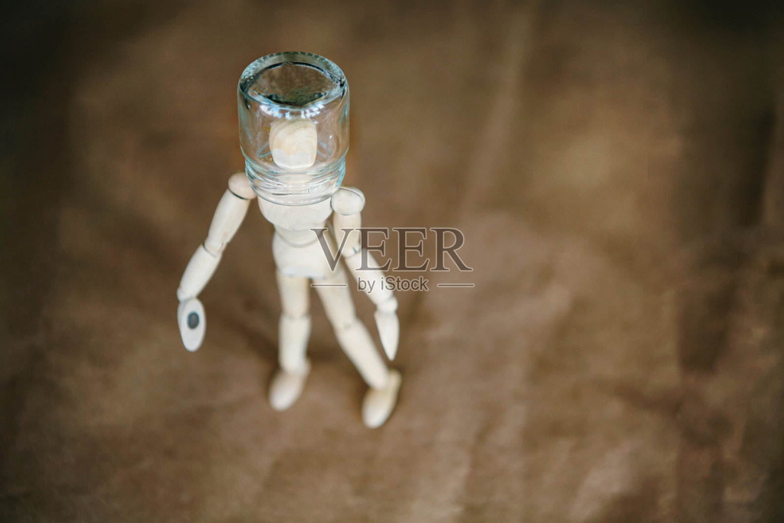 头上顶着罐子的木制小人，背景照片摄影图片