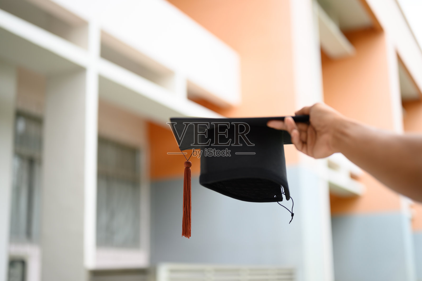 毕业生们手持一顶向前延伸的黑帽。照片摄影图片