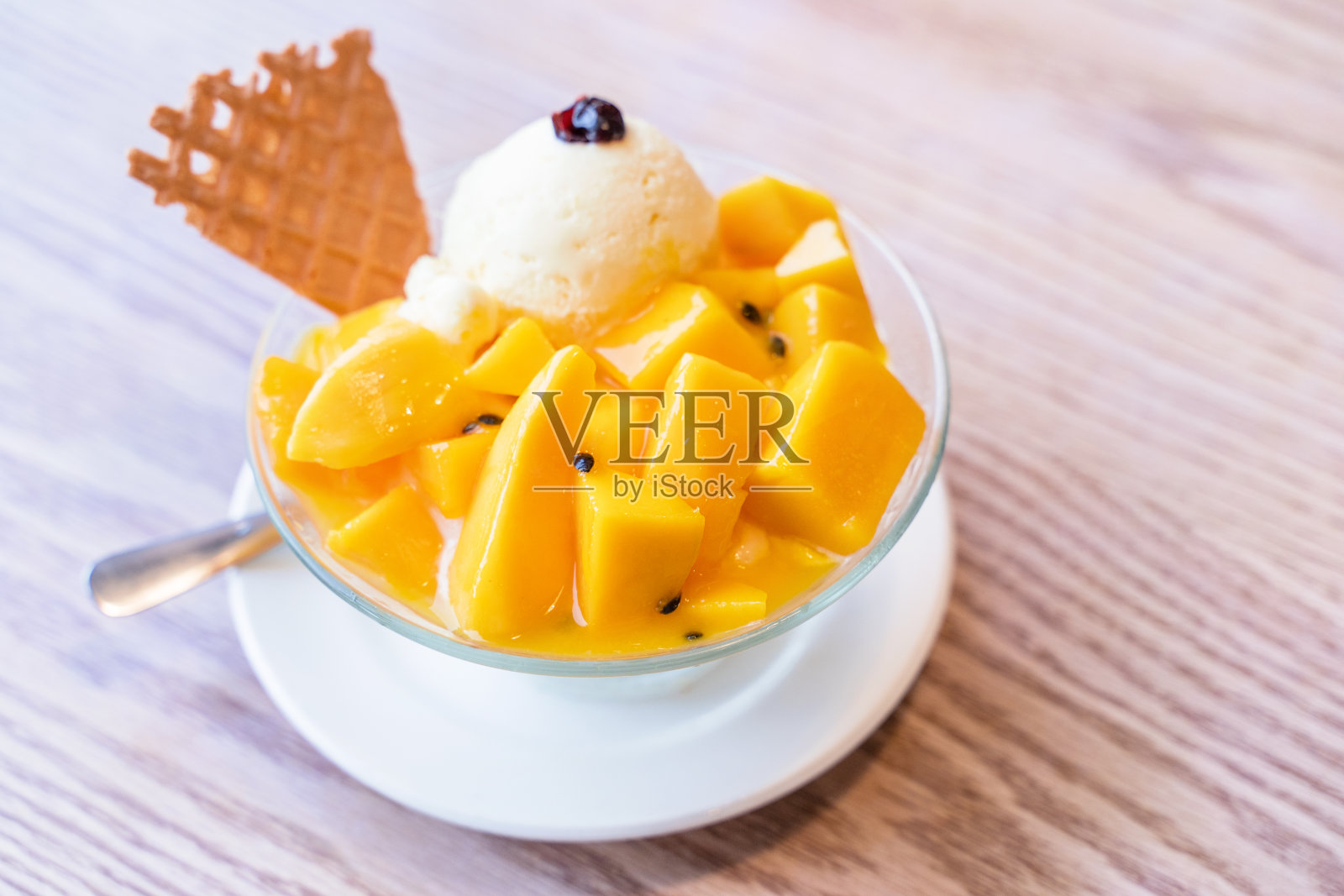 夏日餐厅的新鲜芒果刨冰，加上一勺冰淇淋和果汁酱照片摄影图片