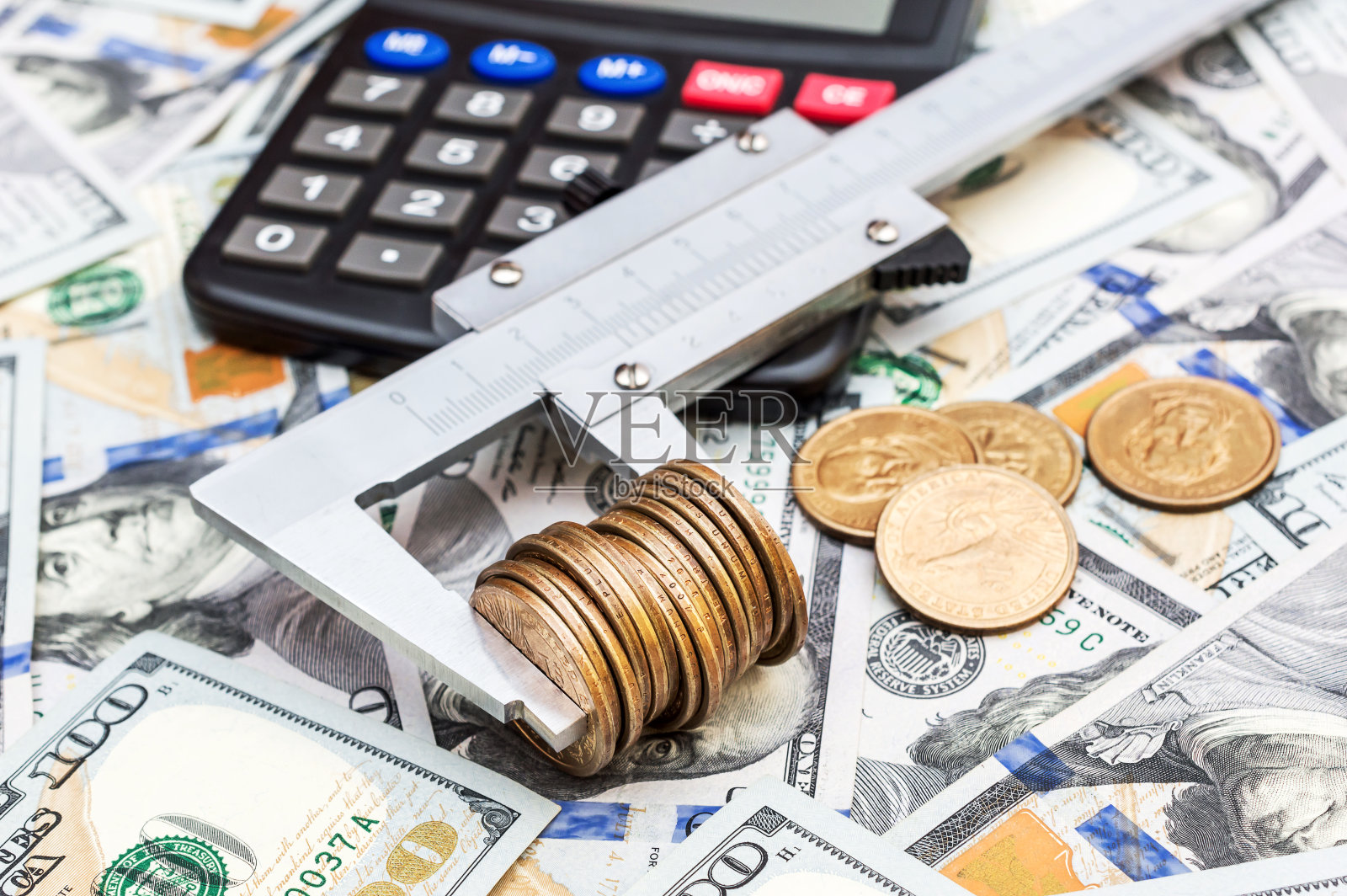 游标卡尺与硬币和计算器的背景钞票。照片摄影图片