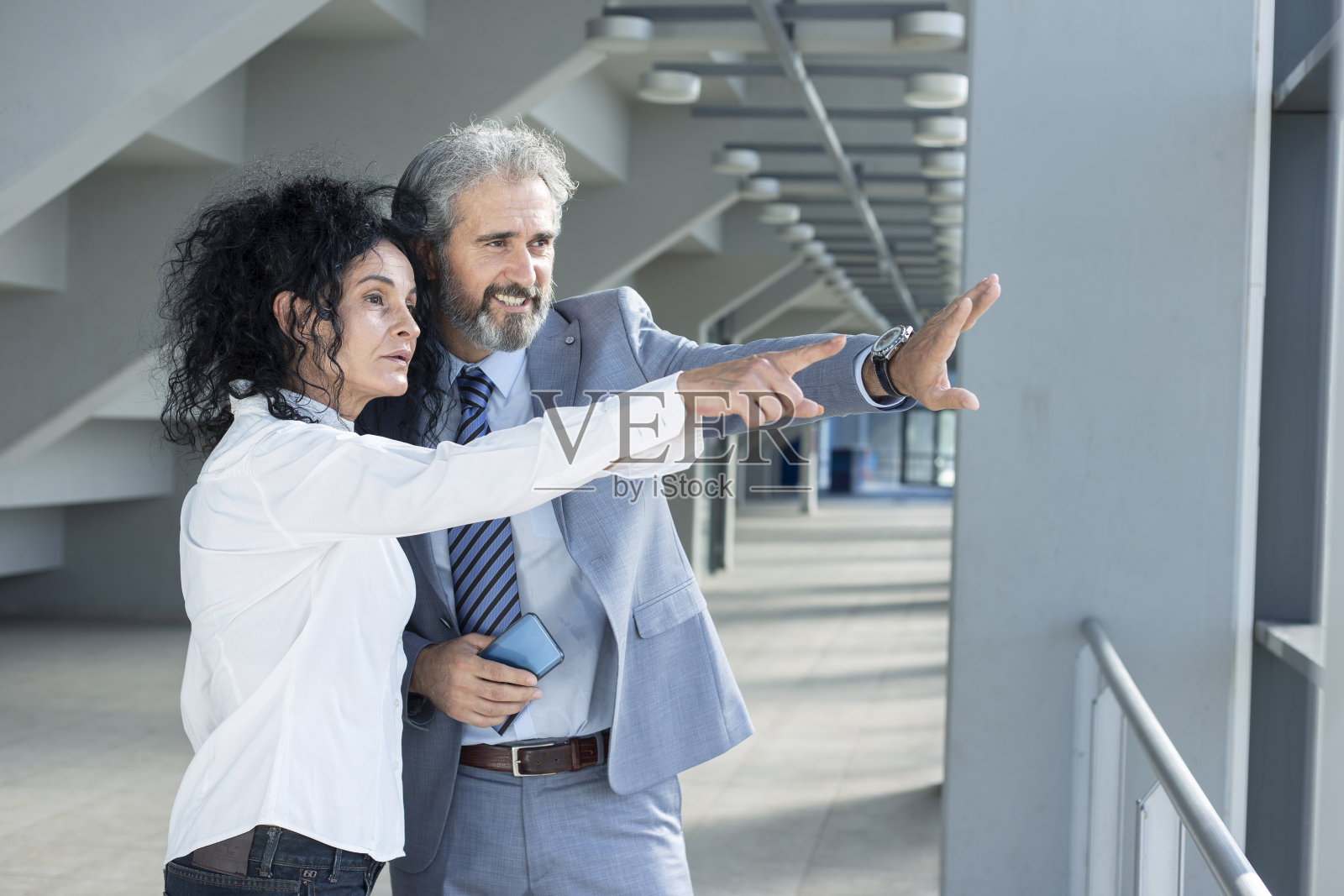 两个资深同事在走廊里聊天，展示项目照片摄影图片