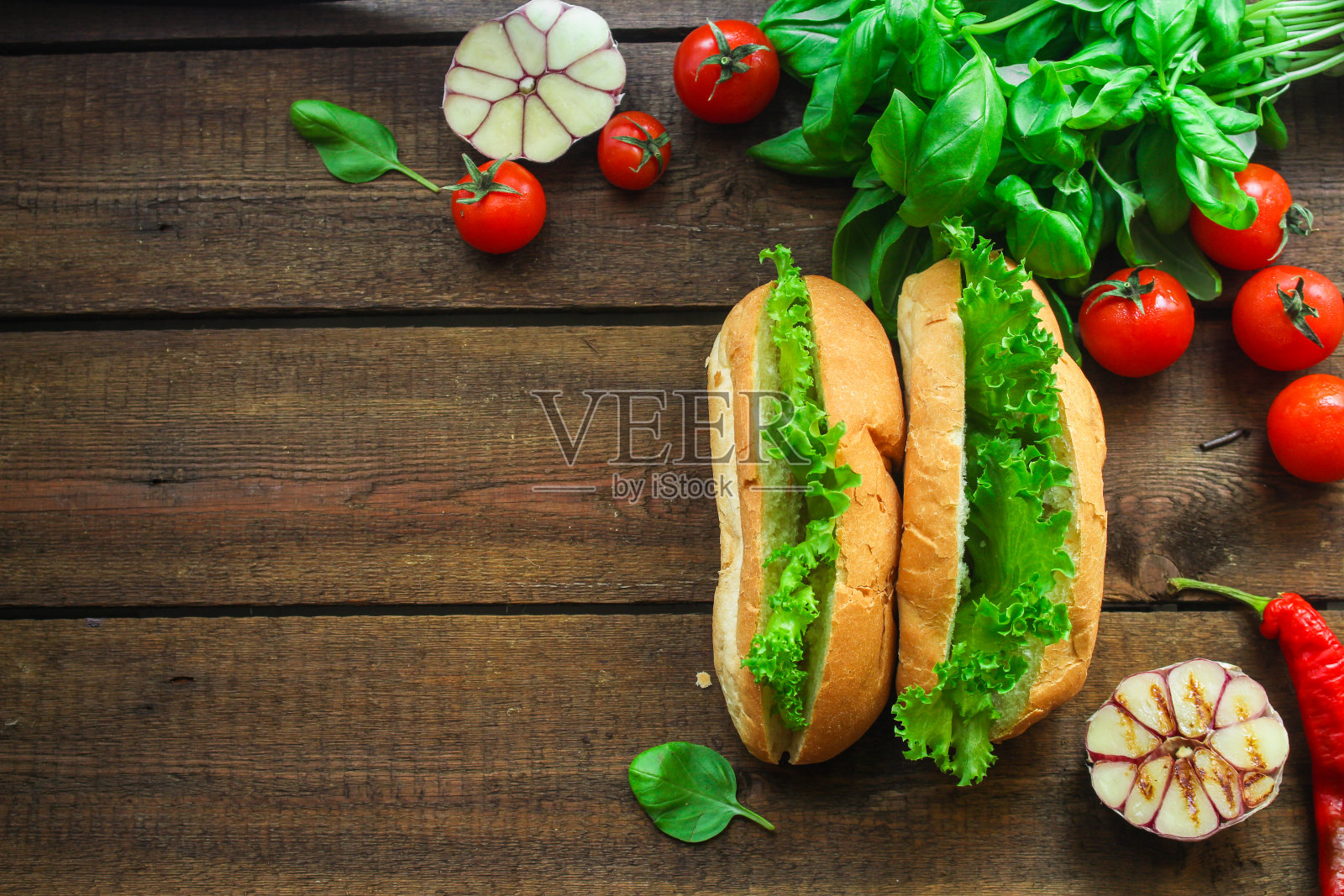 夹莴苣叶和小圆面包的三明治(不加肉)。高级食品背景。本空间照片摄影图片