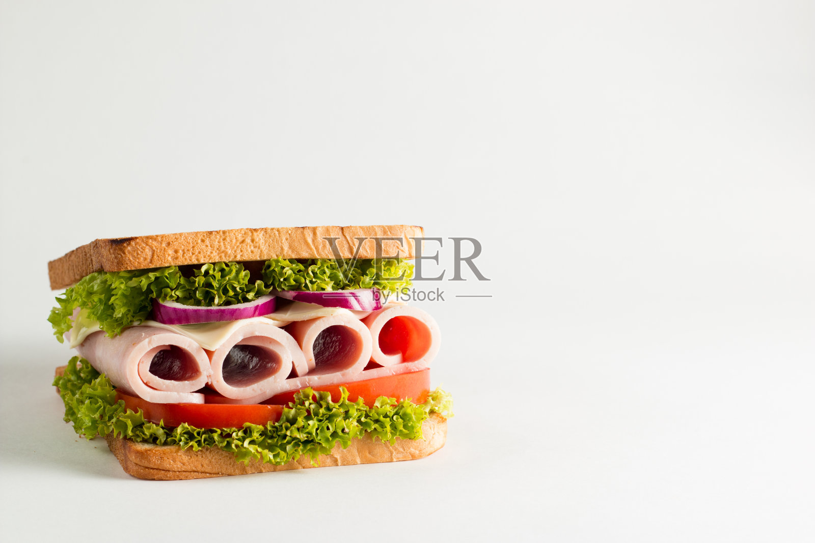 俱乐部三明治的特写照片。三明治与肉，火腿，意大利腊肠，沙拉，蔬菜，生菜，番茄，洋葱和芥末在新鲜的黑麦面包切片在木制背景。橄榄背景。照片摄影图片