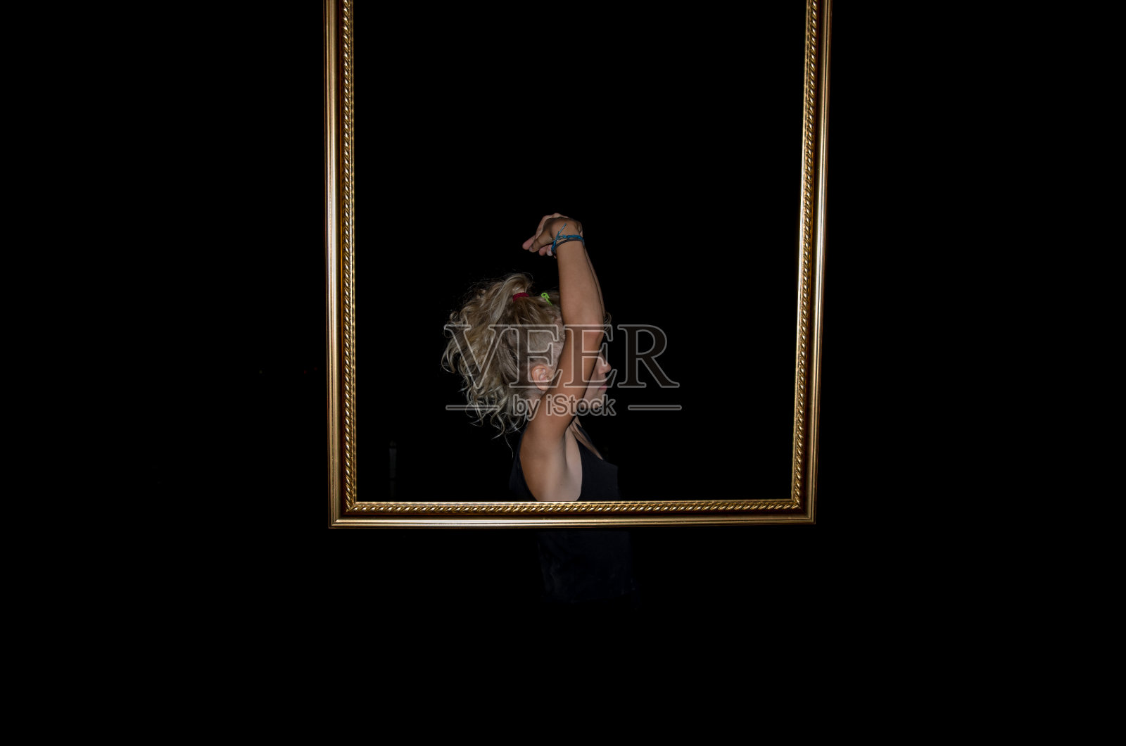 金色镜框后面的小女孩照片摄影图片