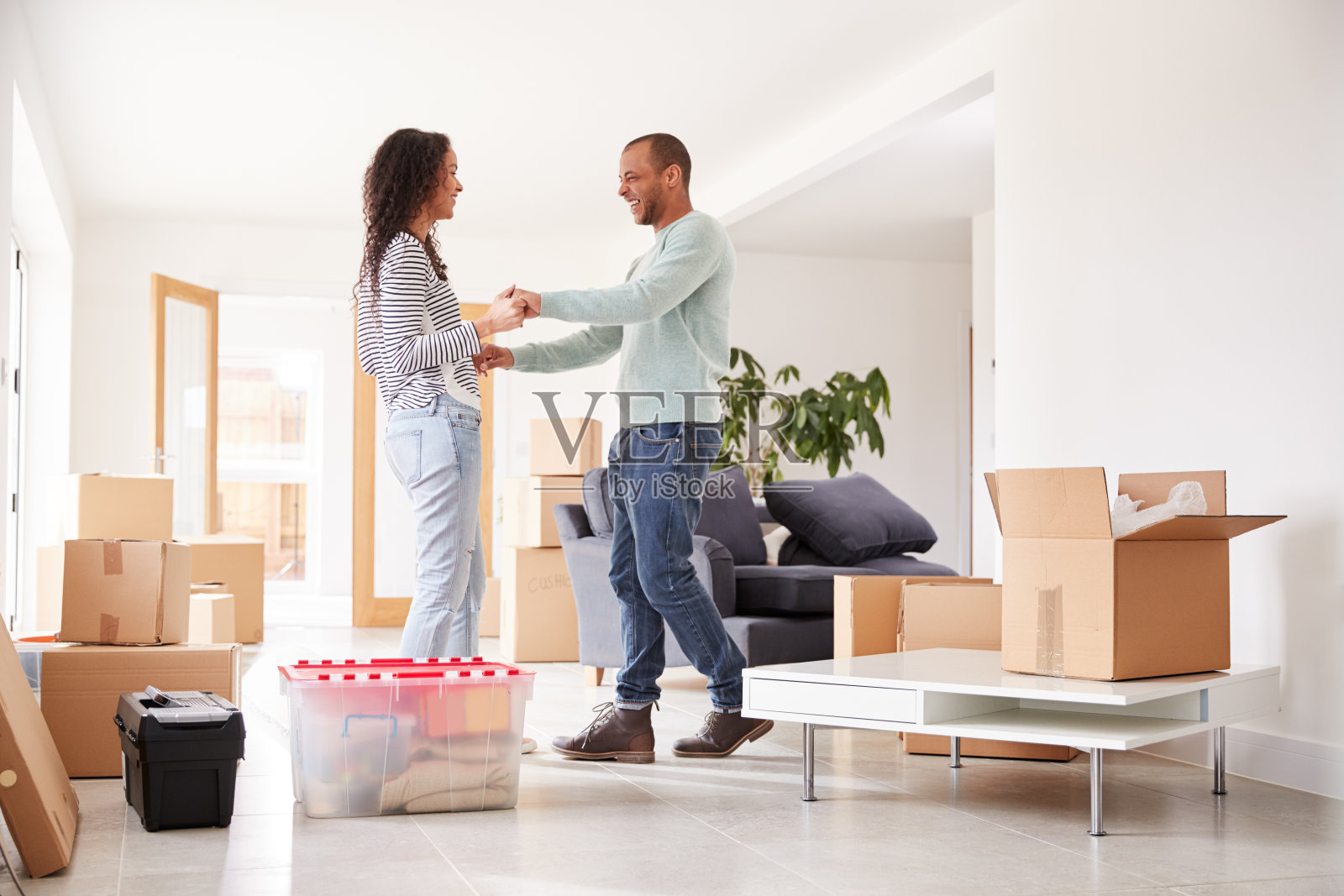 搬家当天，被盒子包围的恩爱夫妇照片摄影图片