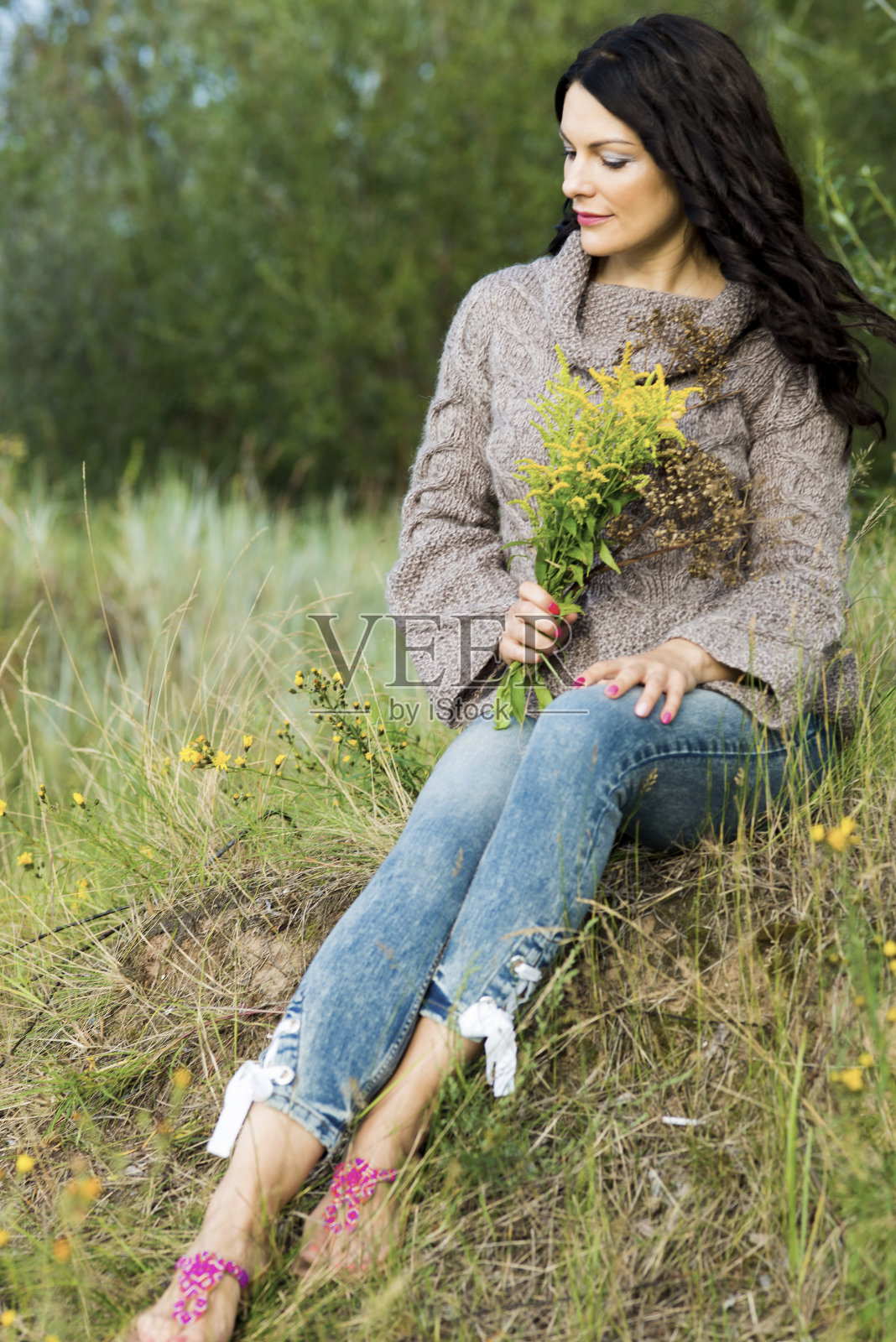 穿着针织套衫的妇女在大自然的背景下摆姿势照片摄影图片