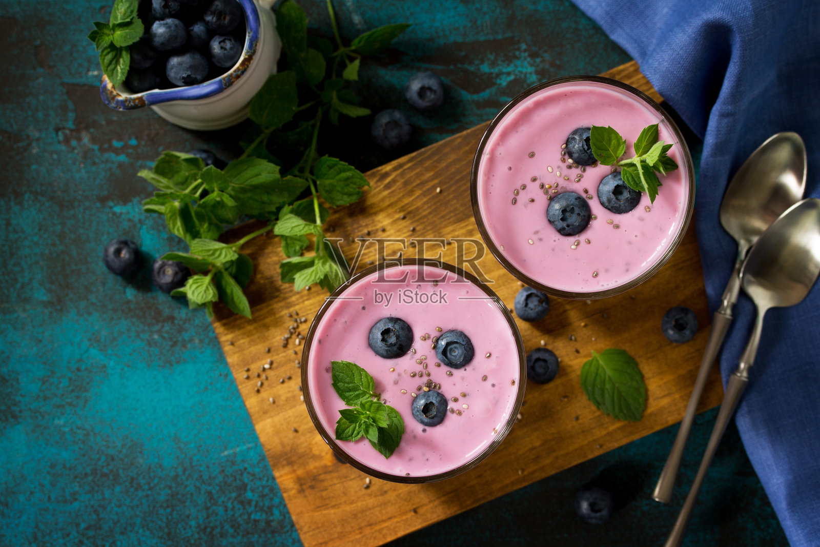 健康的奇亚种子布丁在一个玻璃和蓝莓石板桌上。健康早餐，维生素零食，饮食和健康饮食。俯视图平铺。照片摄影图片