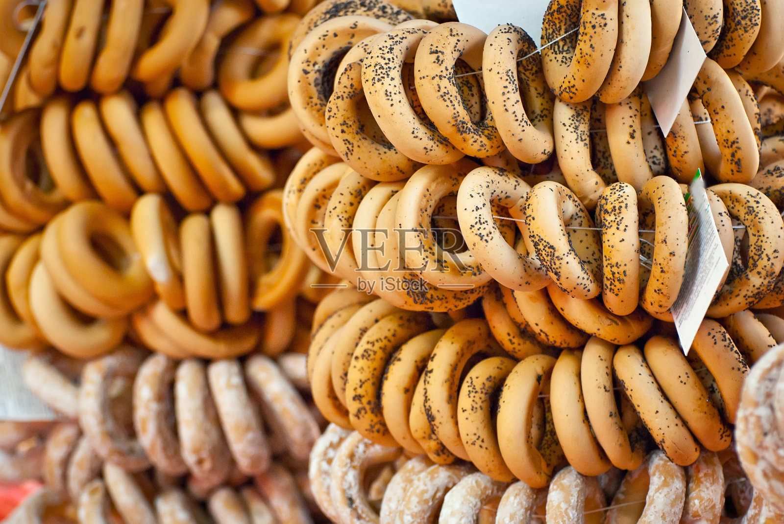 在市集上有许多不同的百吉饼出售。小麦制品用绳子捆扎。照片摄影图片