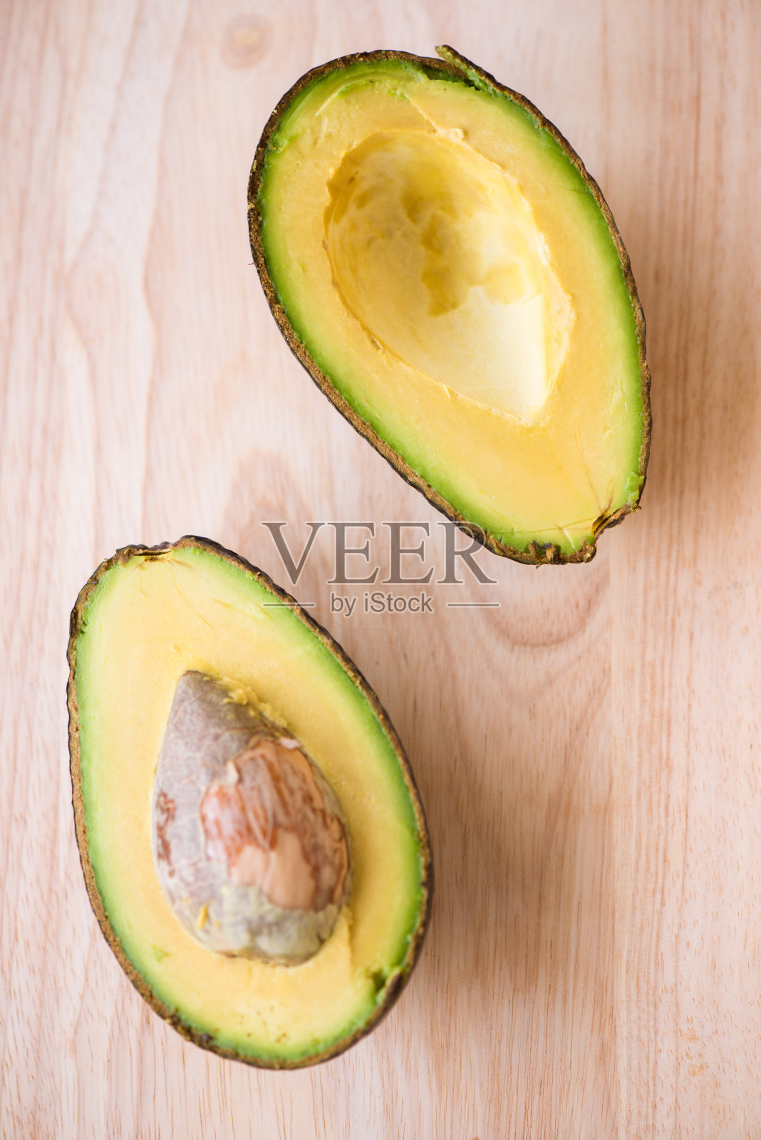 木桌上一个新鲜多汁的牛油果的特写。健康的概念照片摄影图片