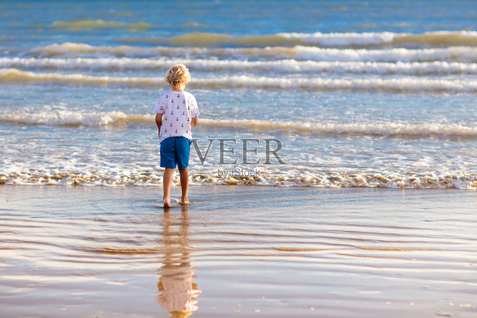 孩子们在热带海滩上玩耍。沙子和水玩具。照片摄影图片