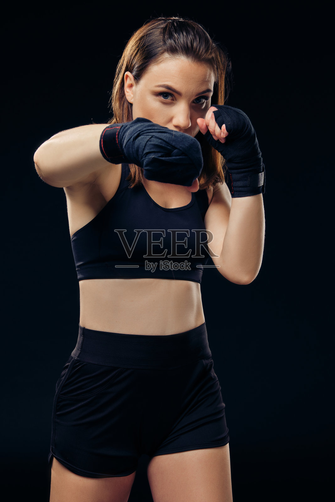 戴拳击手套的女运动员正在演播室练习空手道照片摄影图片