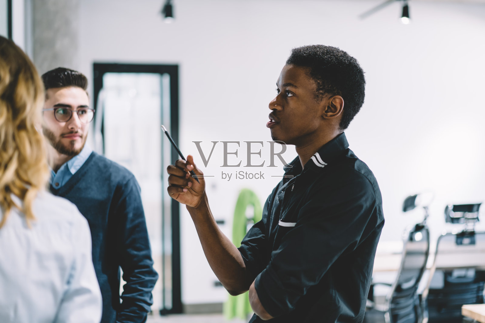 聪明的非洲裔美国年轻骄傲的ceo穿着正式，在现代办公室与专业员工讨论工作计划时思考发展商业战略照片摄影图片