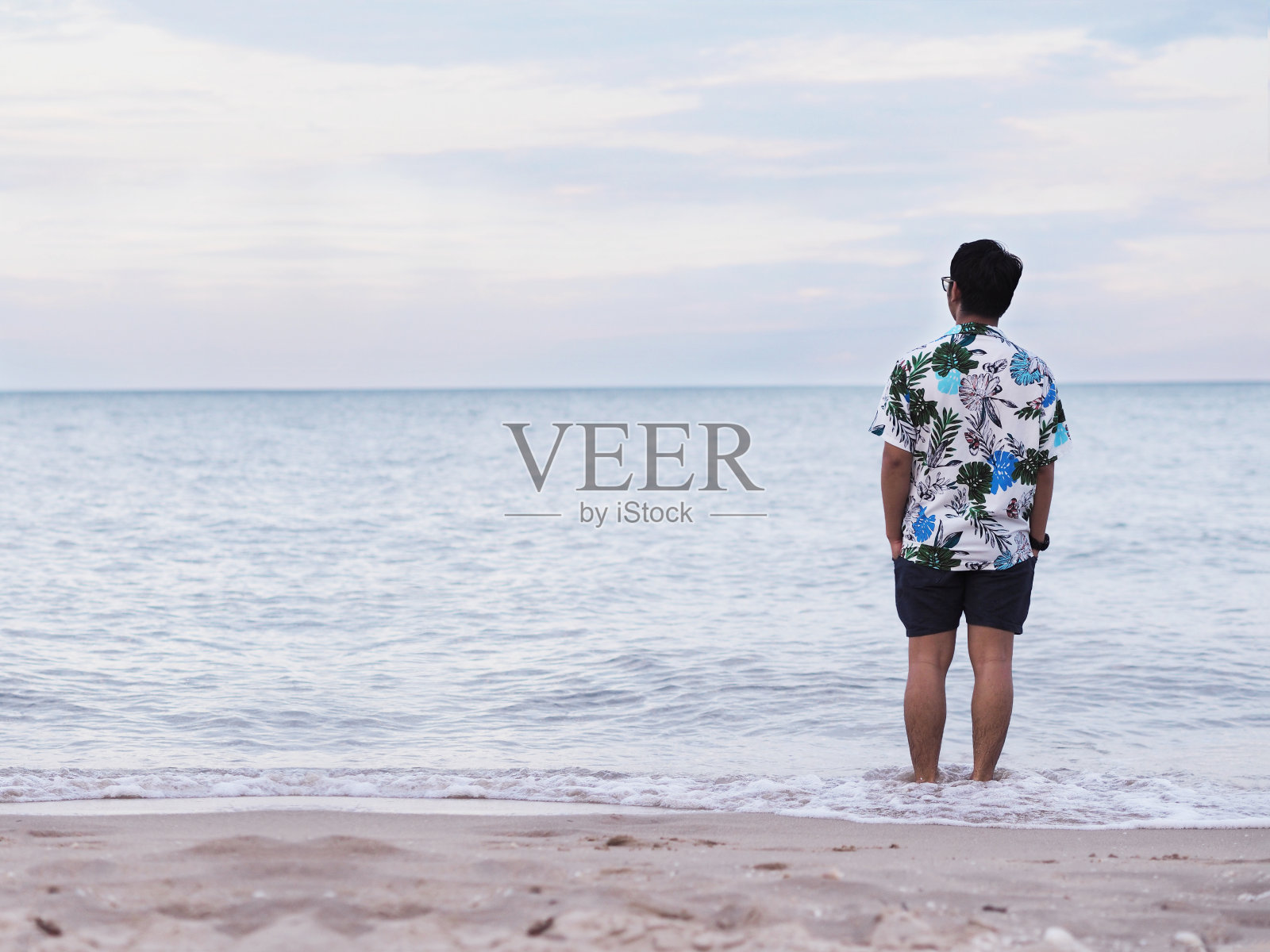 一个人轻松地站在沙滩上照片摄影图片