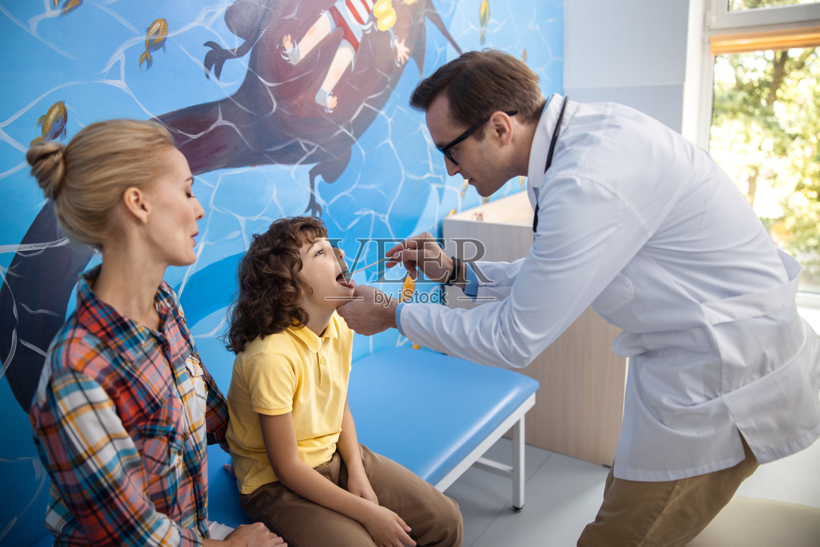 男孩正在医生库存照片上检查喉咙痛照片摄影图片