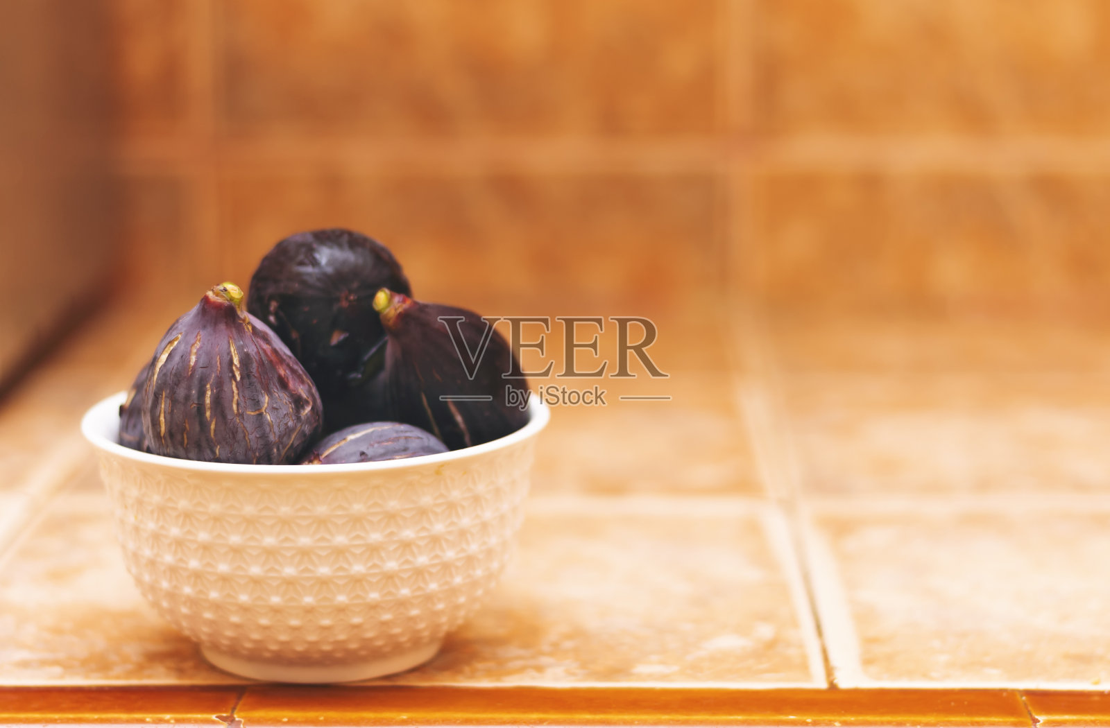 一组无花果在一个白色的碗。照片摄影图片