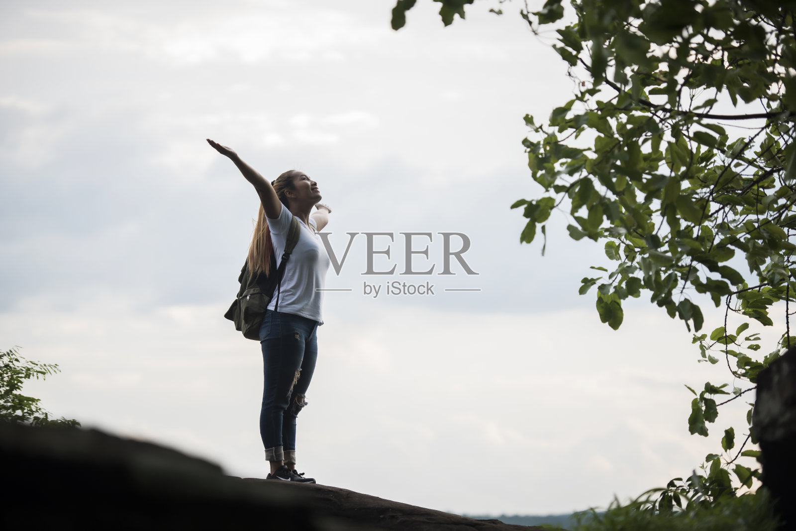 旅游女孩用手臂快乐地与自然靠近河边。旅行的概念。照片摄影图片