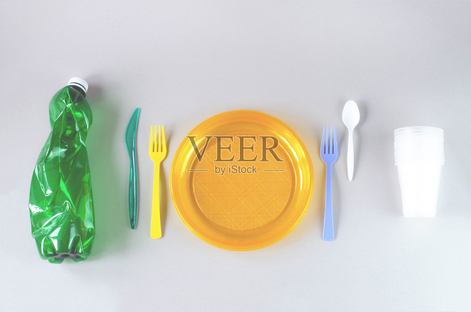 灰色背景上的塑料餐具和塑料袋。照片摄影图片