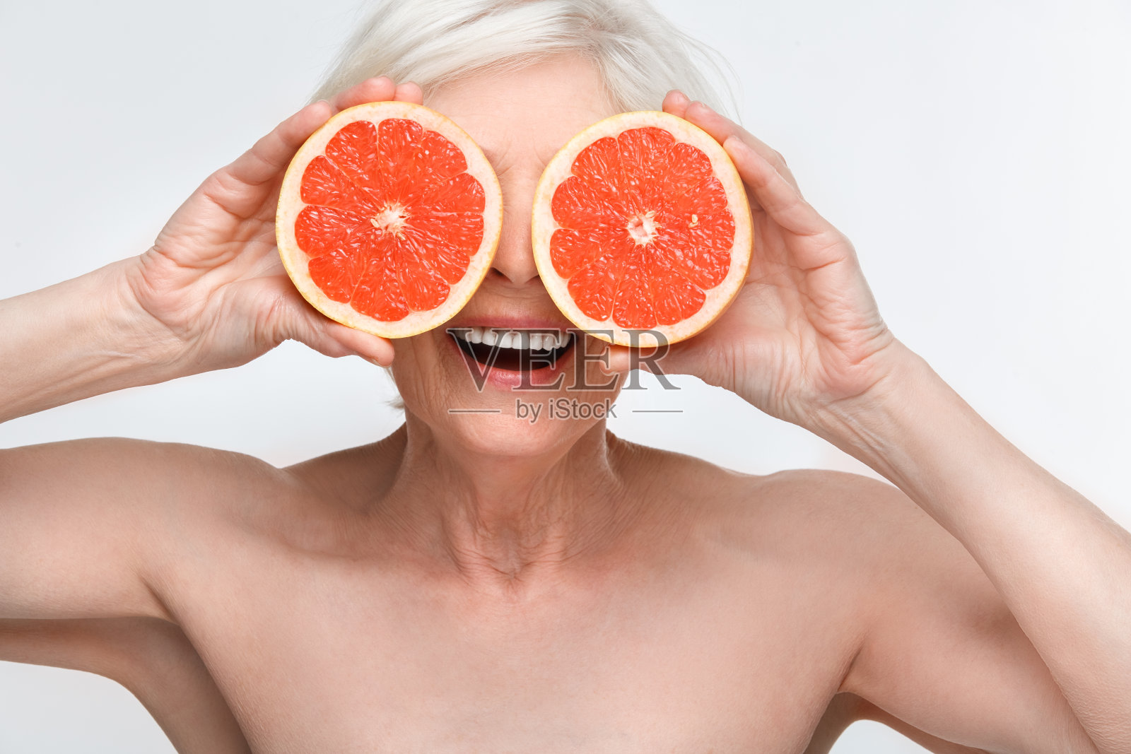 资深女子工作室在白墙上隔离美女概念，用葡萄柚遮住眼睛搞笑照片摄影图片