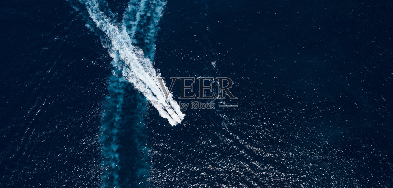 从上面俯瞰，豪华游艇在蓝色海面上航行的令人惊叹的鸟瞰图。翡翠海岸(翡翠海岸)撒丁岛，意大利。照片摄影图片