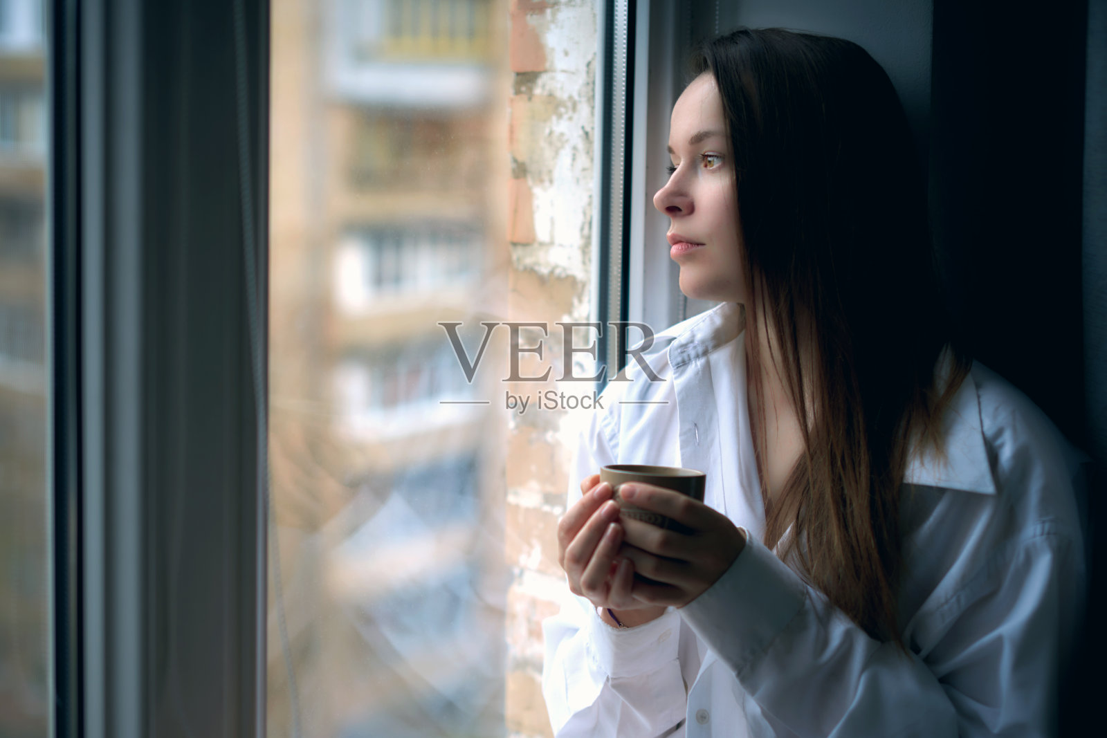 坐在窗边喝咖啡的年轻女子照片摄影图片