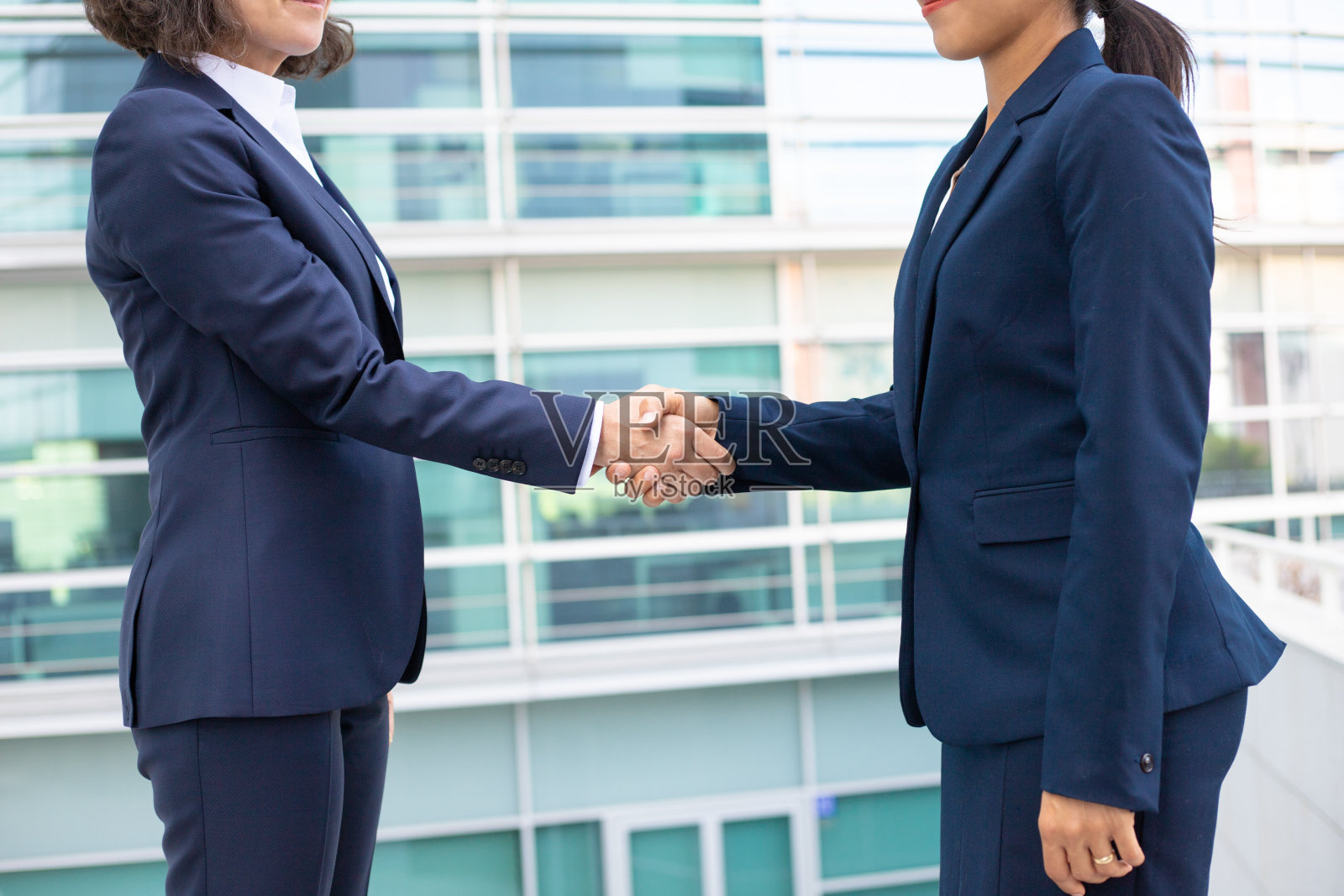 同事们在办公楼附近握手的镜头。照片摄影图片