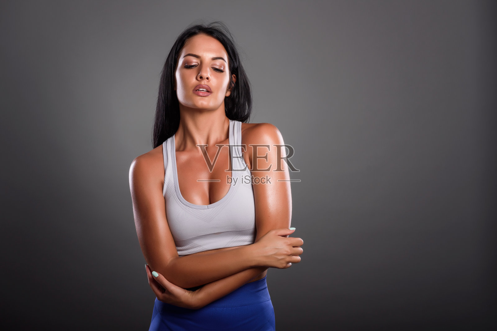 年轻漂亮的健身女性。健身教练女孩在工作室摆姿势。照片摄影图片